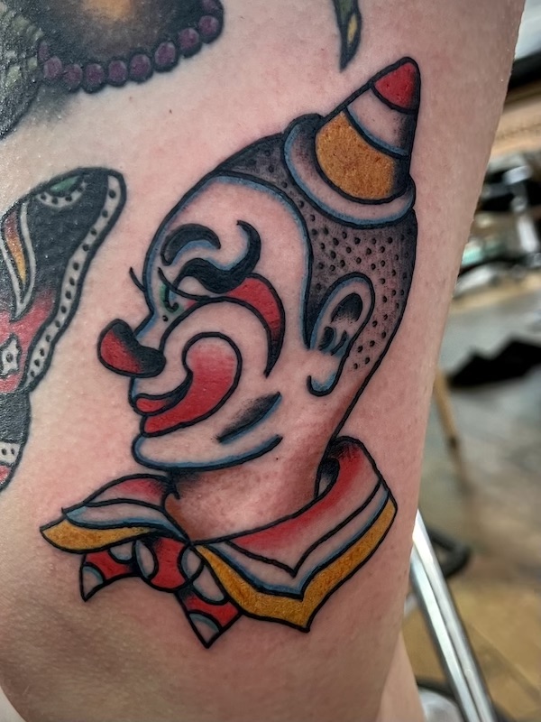 Clown boy tattooed in the American Traditional style. Made at Denver's finest Dedication Tattoo.